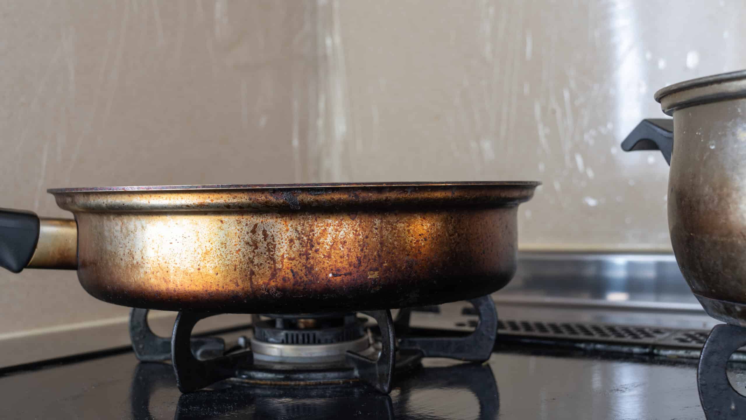 Unterseite einer verschmutzten Antihaftpfanne, Methode zum Reinigen